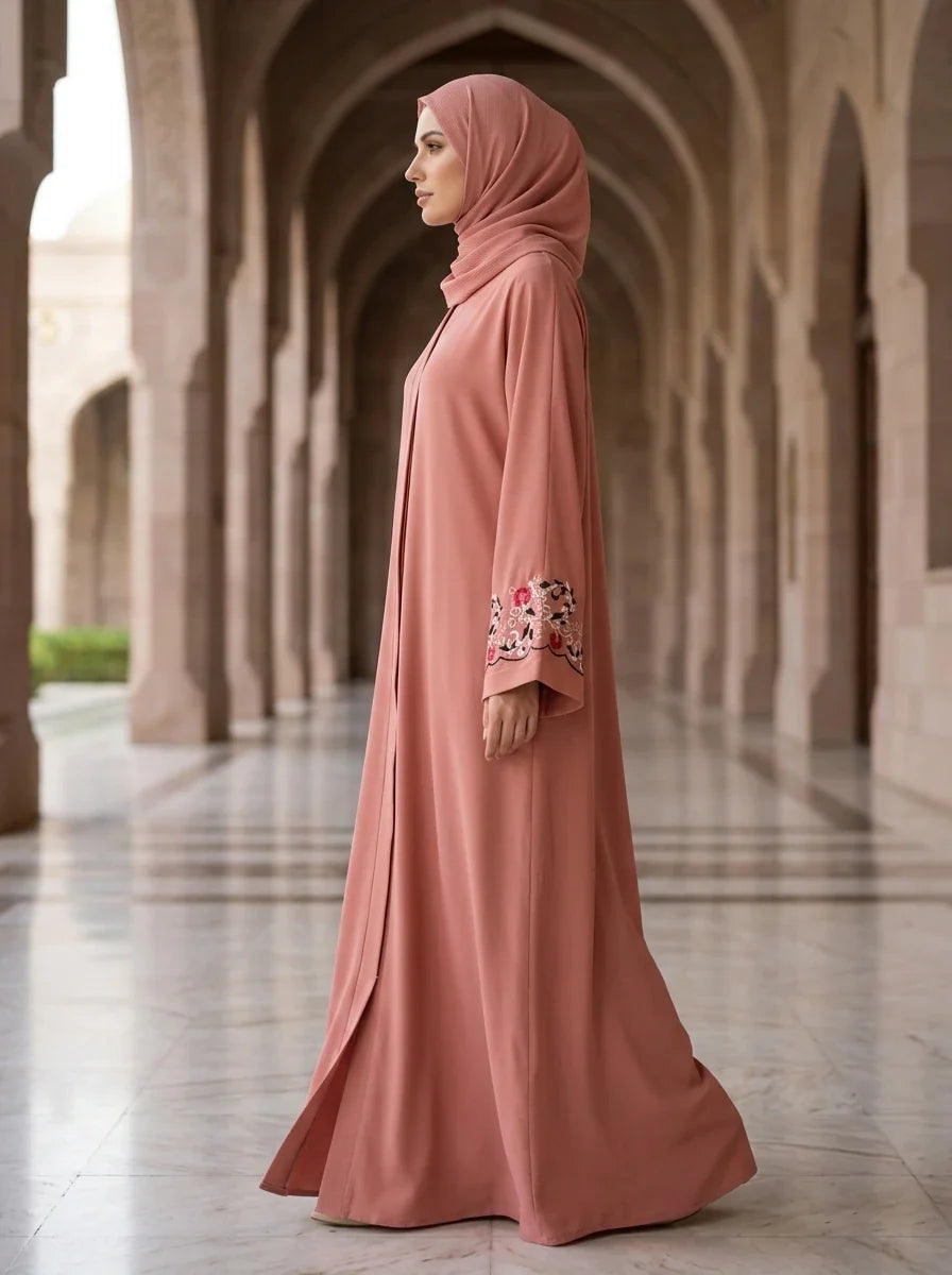Model walking through mosque courtyard wearing pink Arwa Abaya