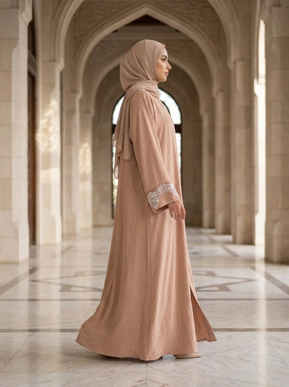 Model walking through mosque courtyard in pink Aleena Abaya