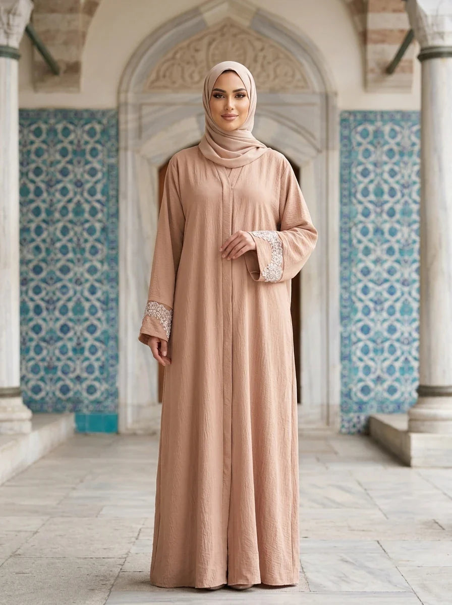 Model wearing pink Aleena Abaya in courtyard setting