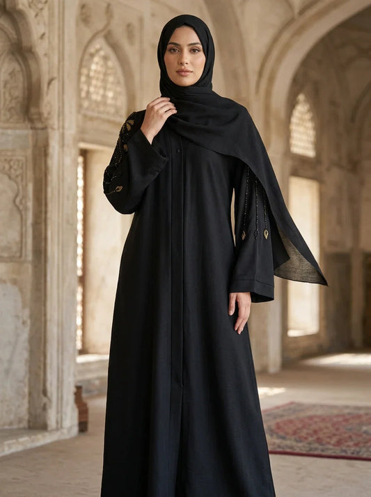 Wafa Abaya in Black — wide bell sleeves with dangling beaded tassels, front view